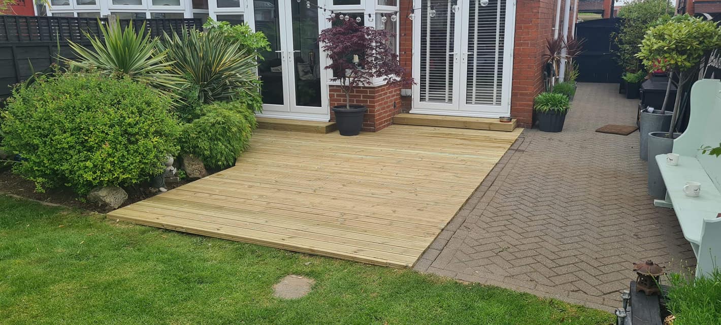 Garden decking laid against a patio with planting
